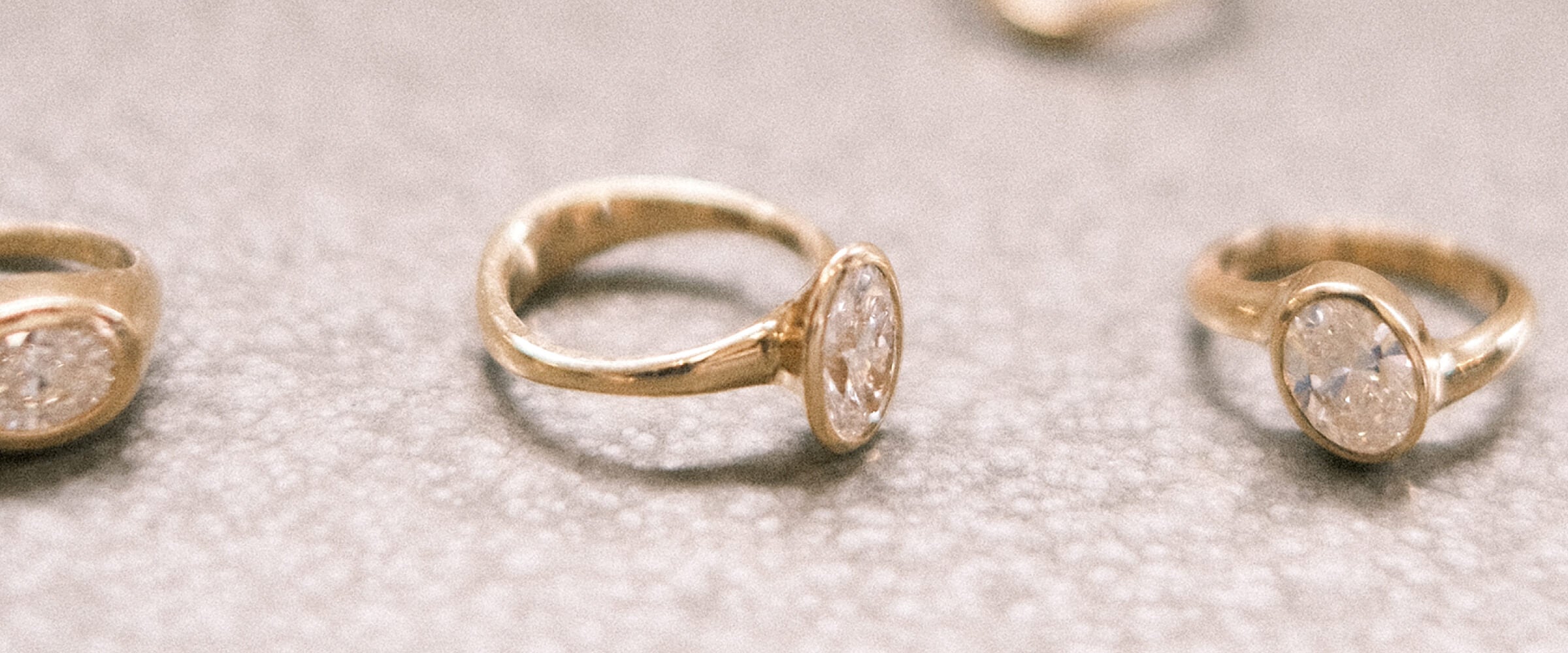 Gold diamond rings laying on a textured surface