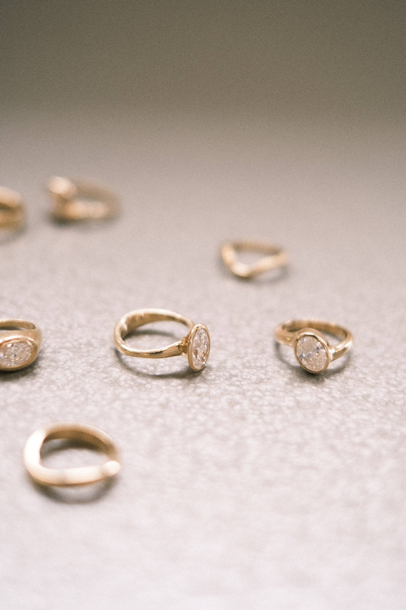 Gold diamond rings resting on a textured surface