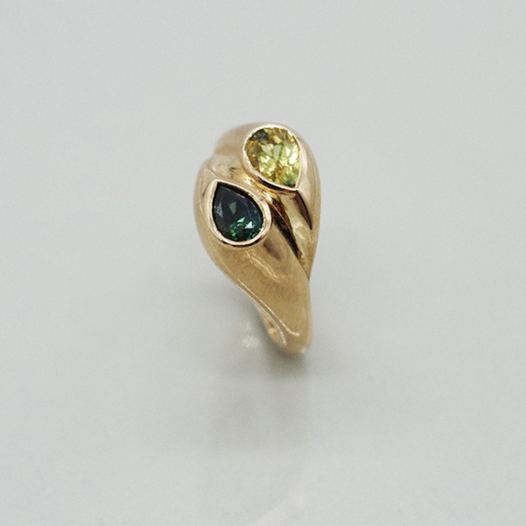 Gold ring with a black gemstone on a light gray background