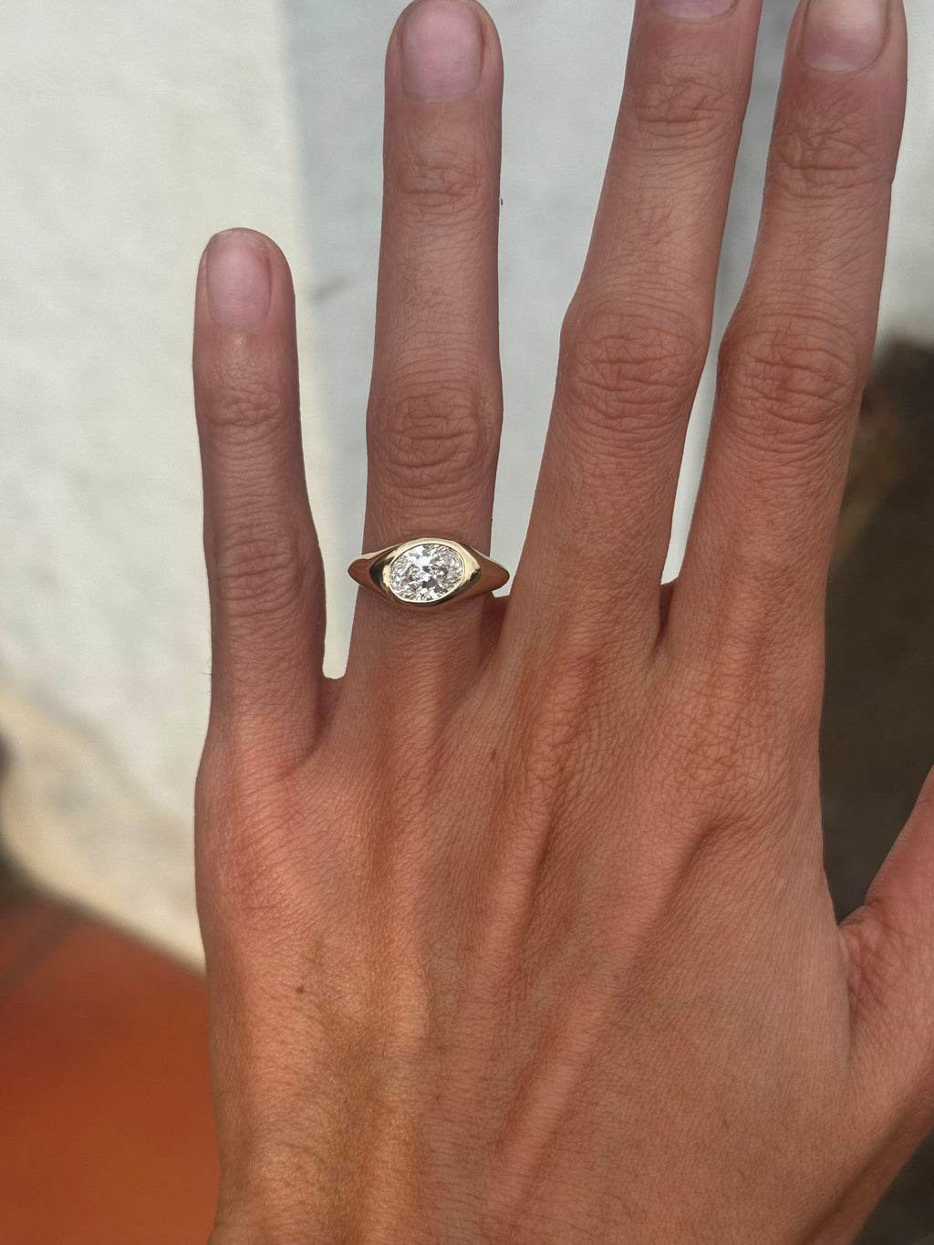 Hand wearing a diamond ring with a blurred background