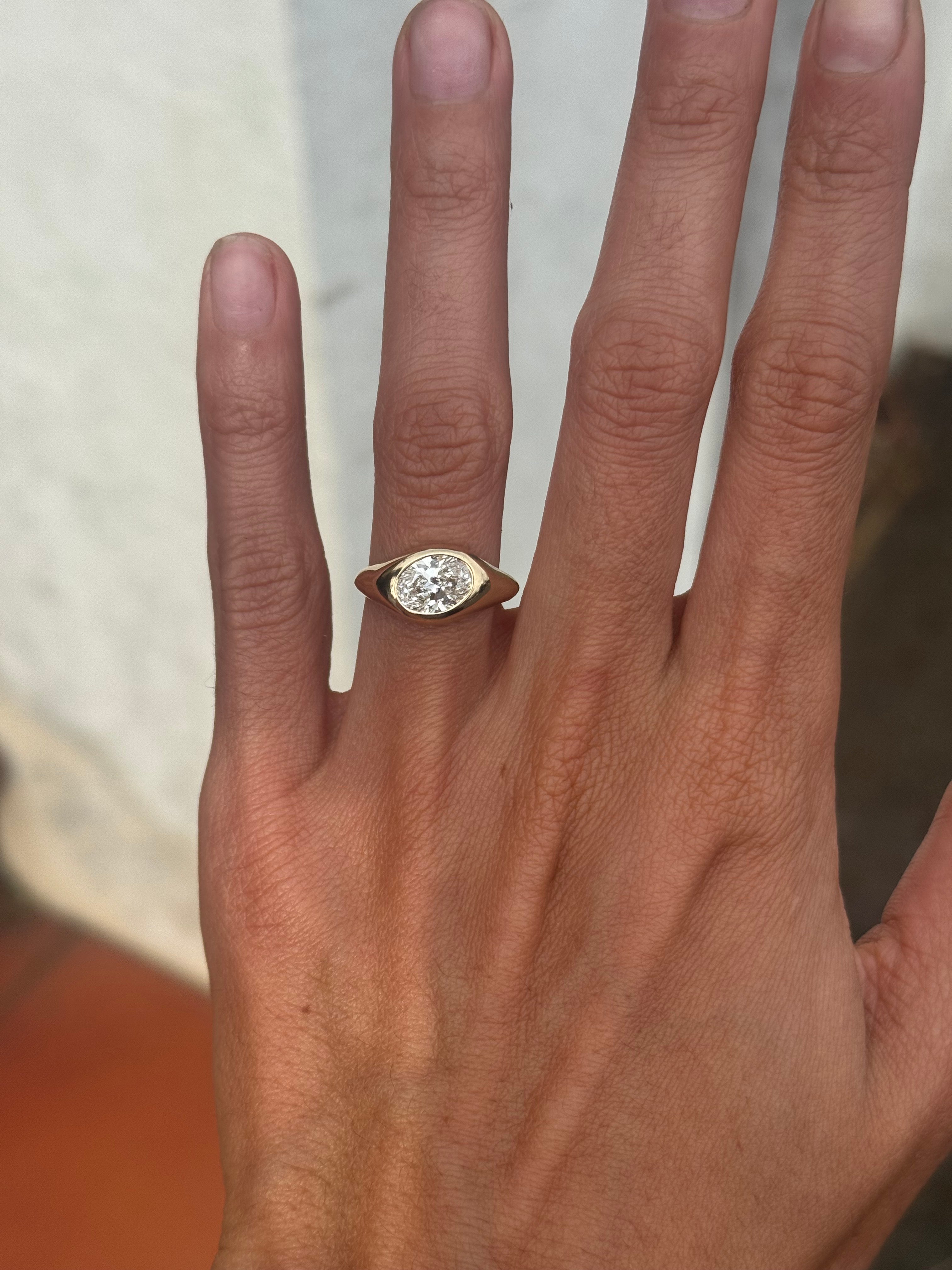 Hand wearing a diamond ring with a blurred background