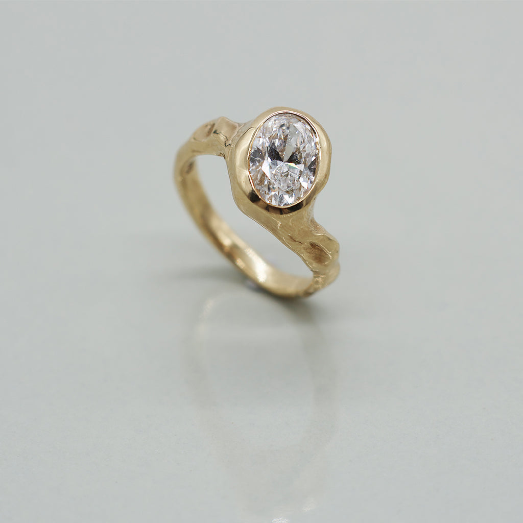 Gold ring with a diamond on a light gray background