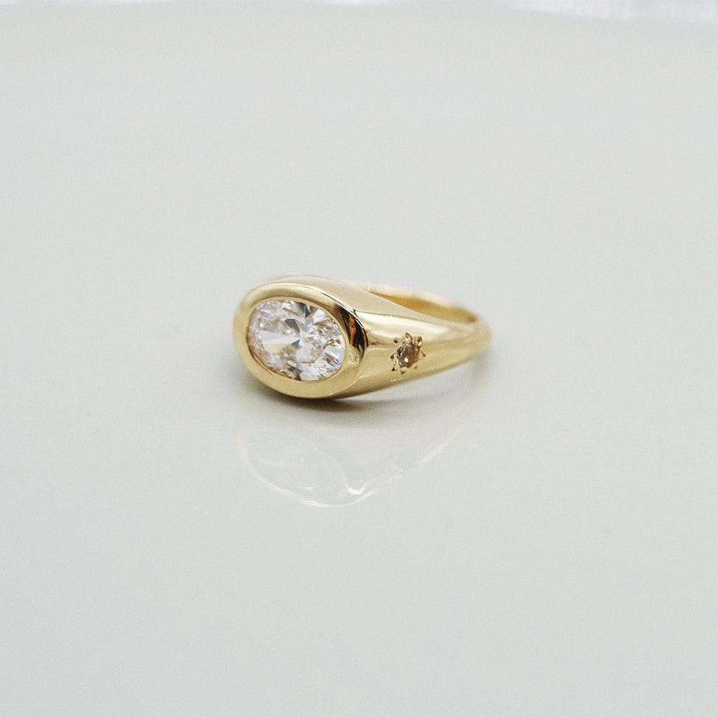 Gold ring with a diamond on a light gray background