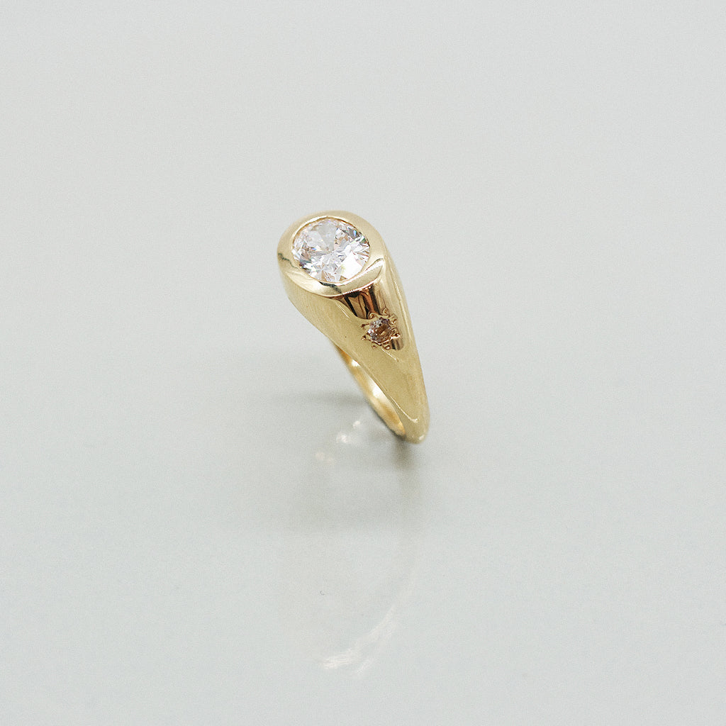 Gold ring with a diamond on a light gray background