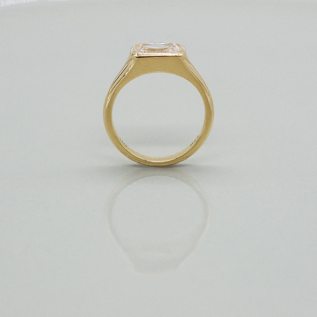 A yellow gold cushion ring featuring a large cushion brilliant-cut diamond center stone, set against a clean white background with a soft reflection.