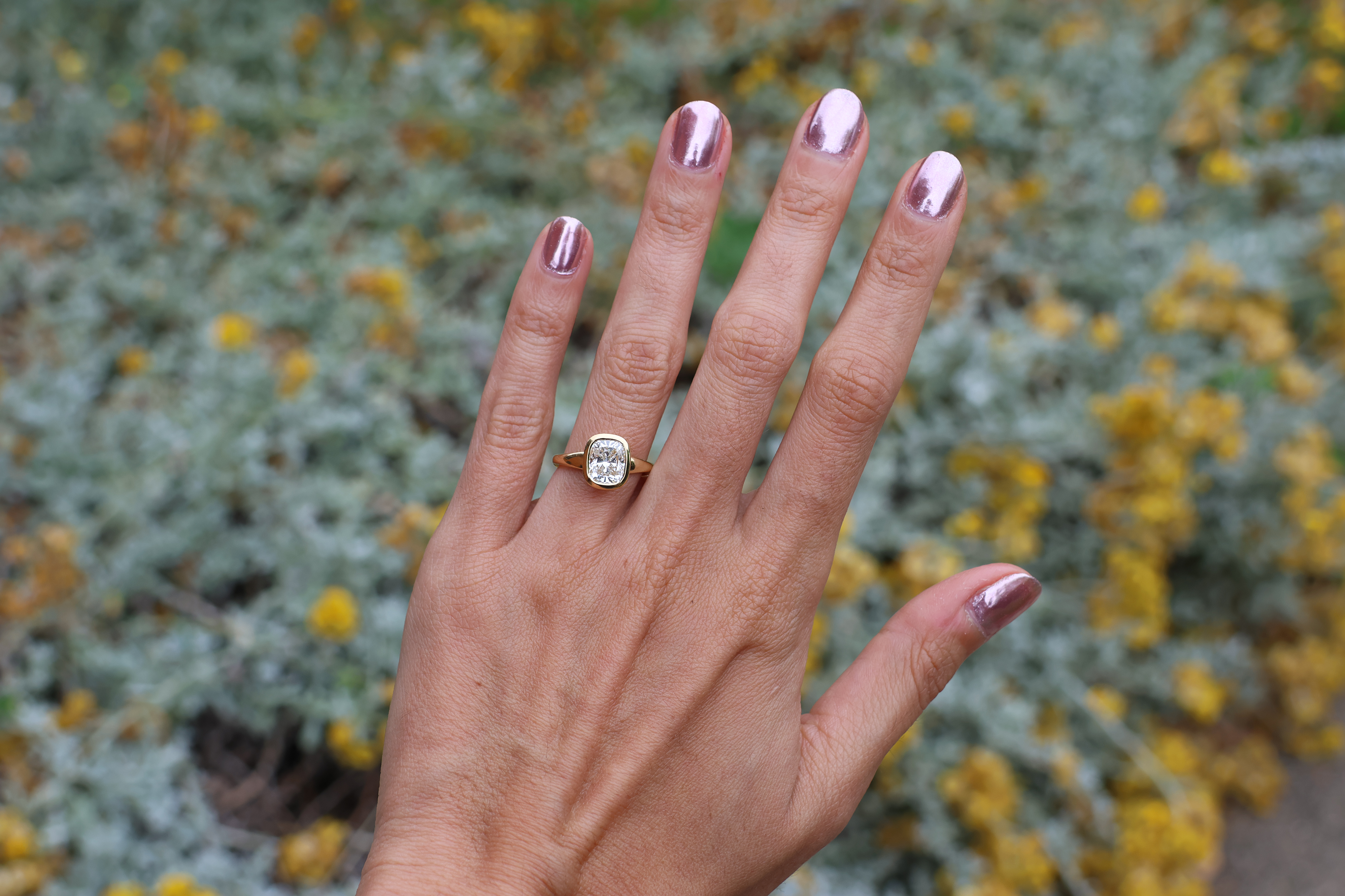 Hand with a ring on a blurred natural background