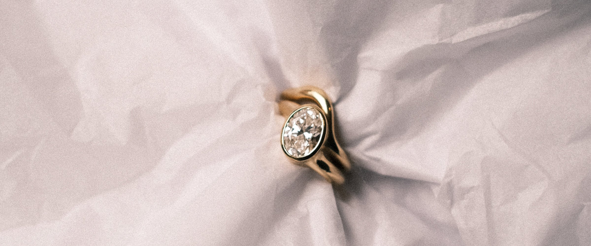 Gold engagement ring with a diamond stacked with a gold wedding band.