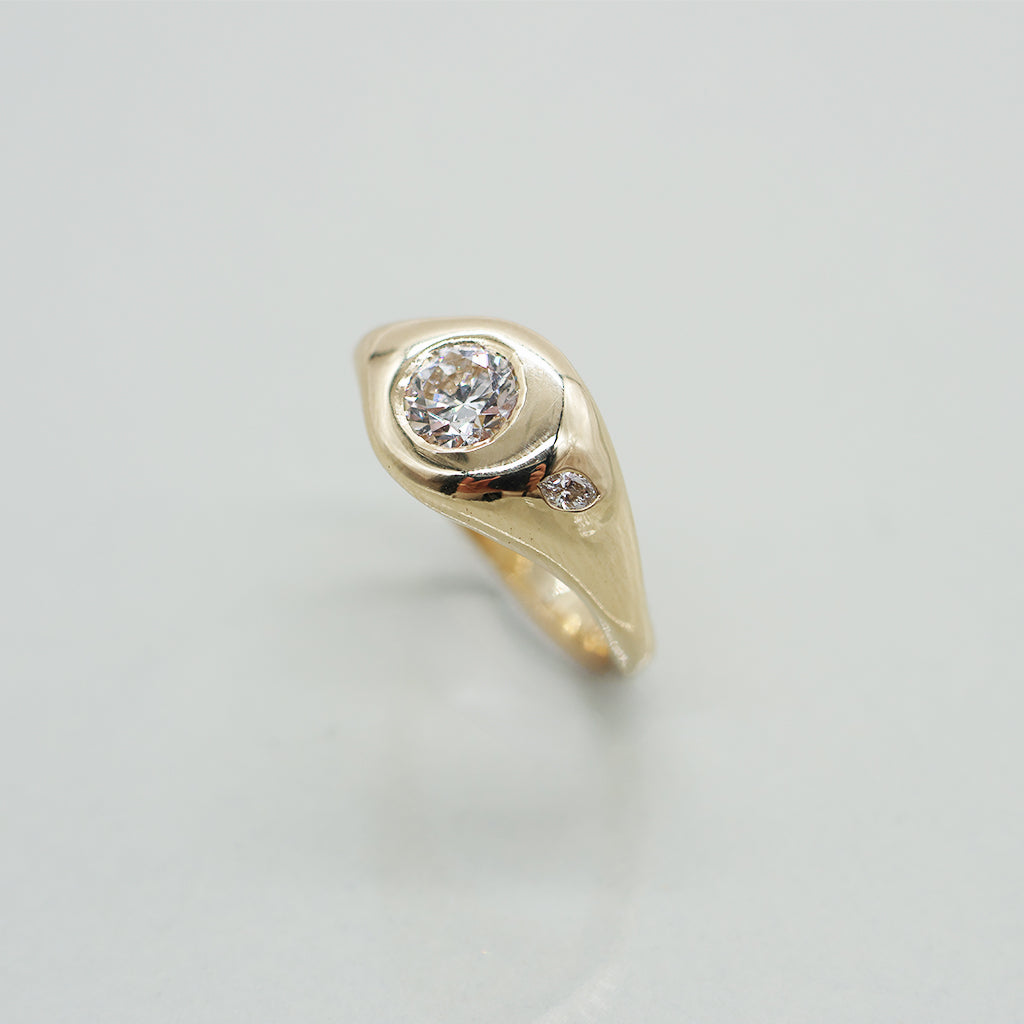 Gold ring with a diamond on a light gray background