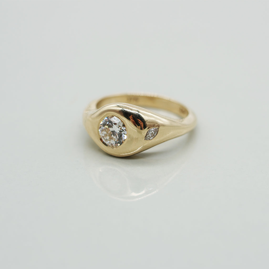 Gold ring with a diamond on a light gray background
