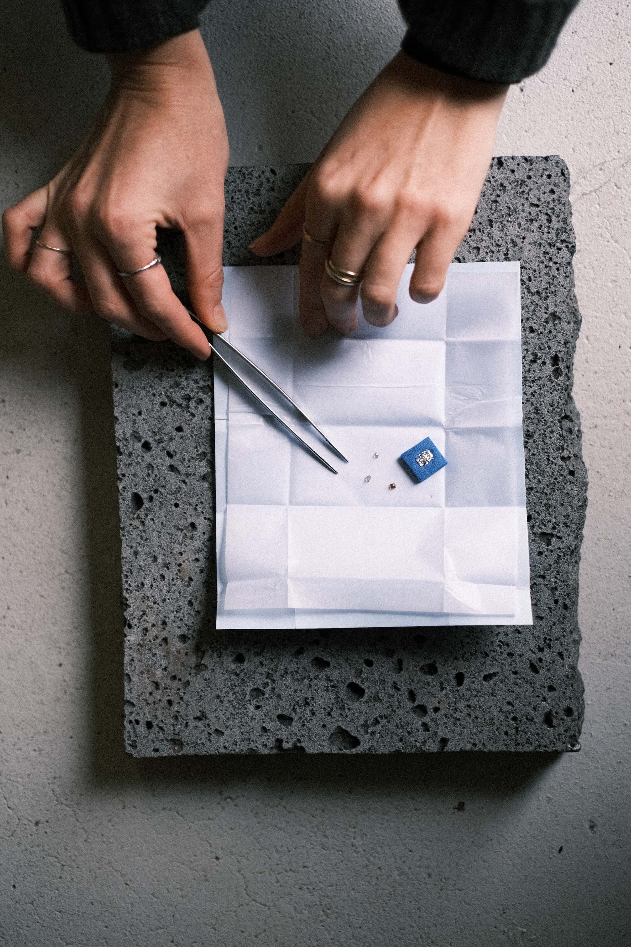Jeweller handling loose diamonds and stones with a small hand tool