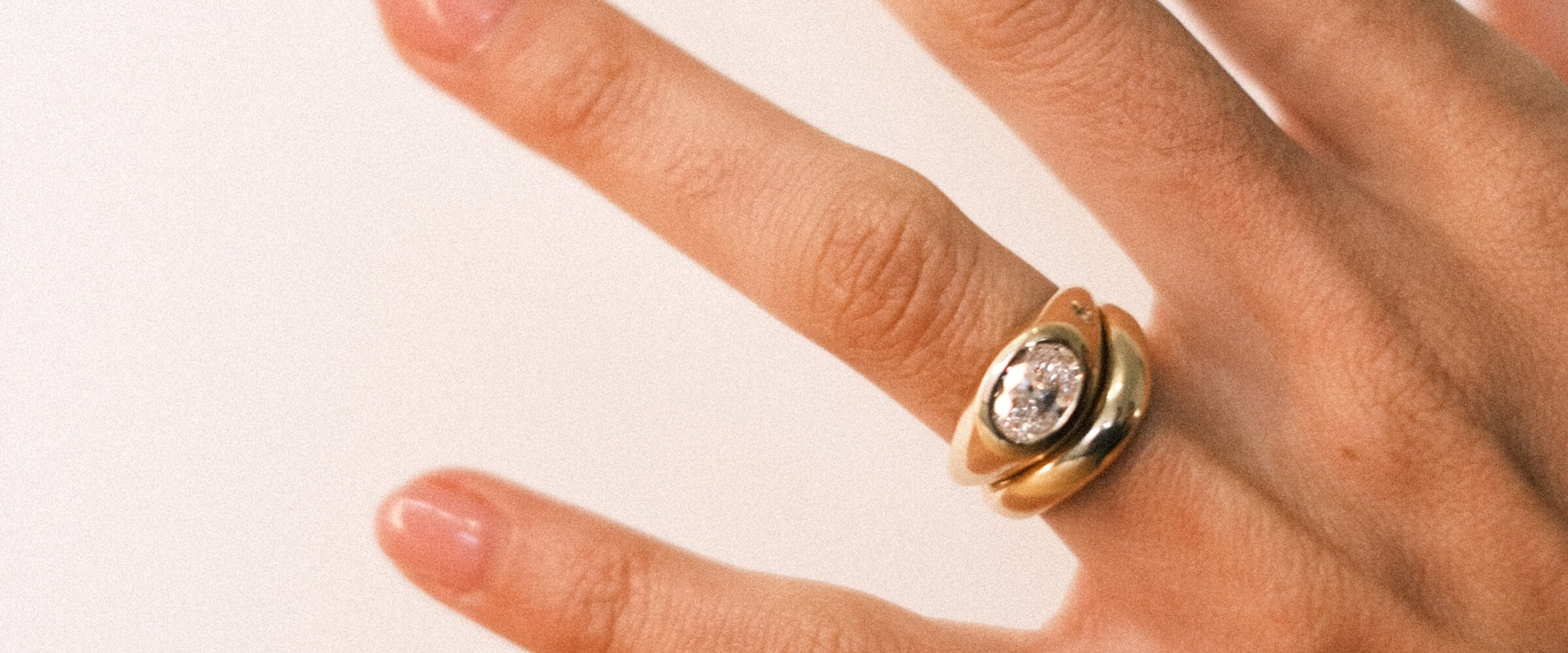 Gold ring with a diamond and a plain gold band on a hand