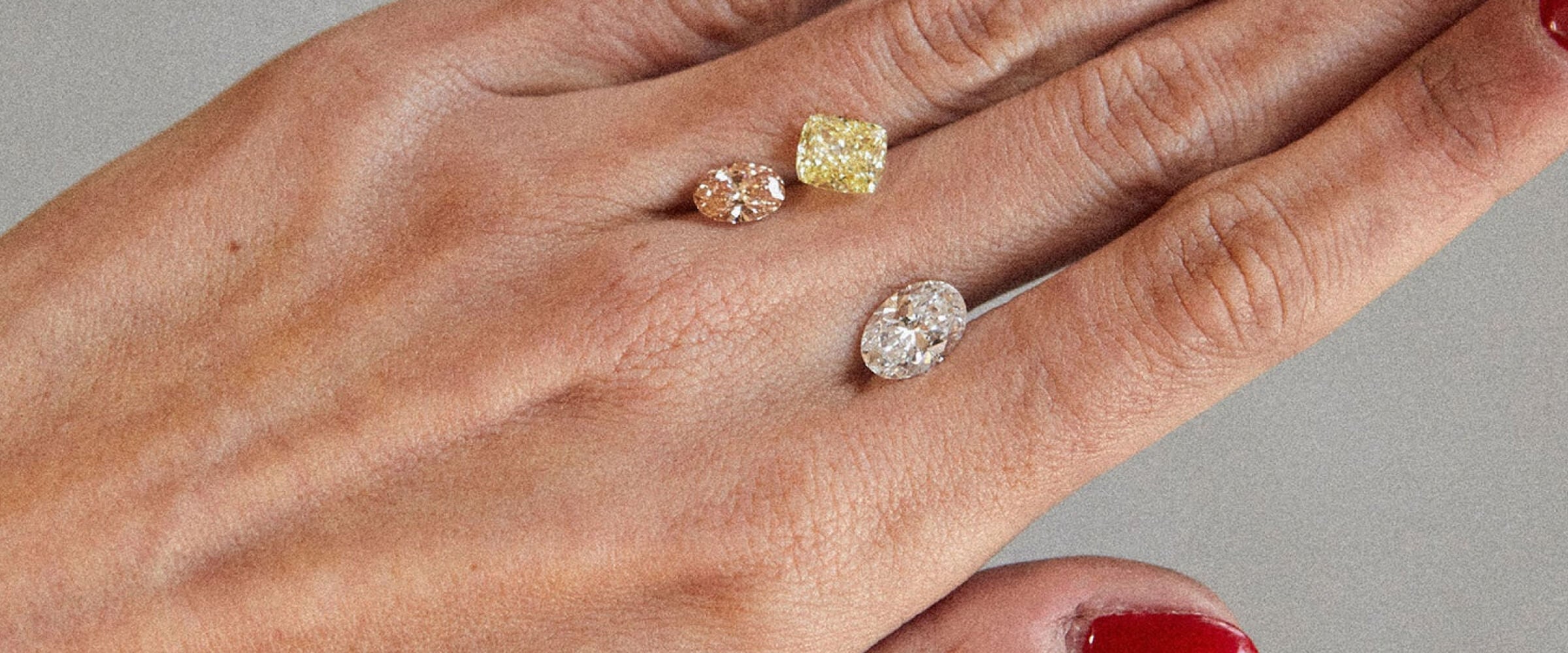 Three diamonds of different colours resting on a hand