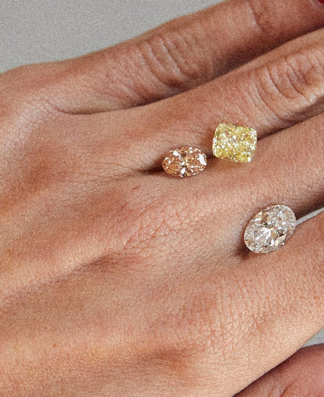 Three different coloured stones held on a hand 